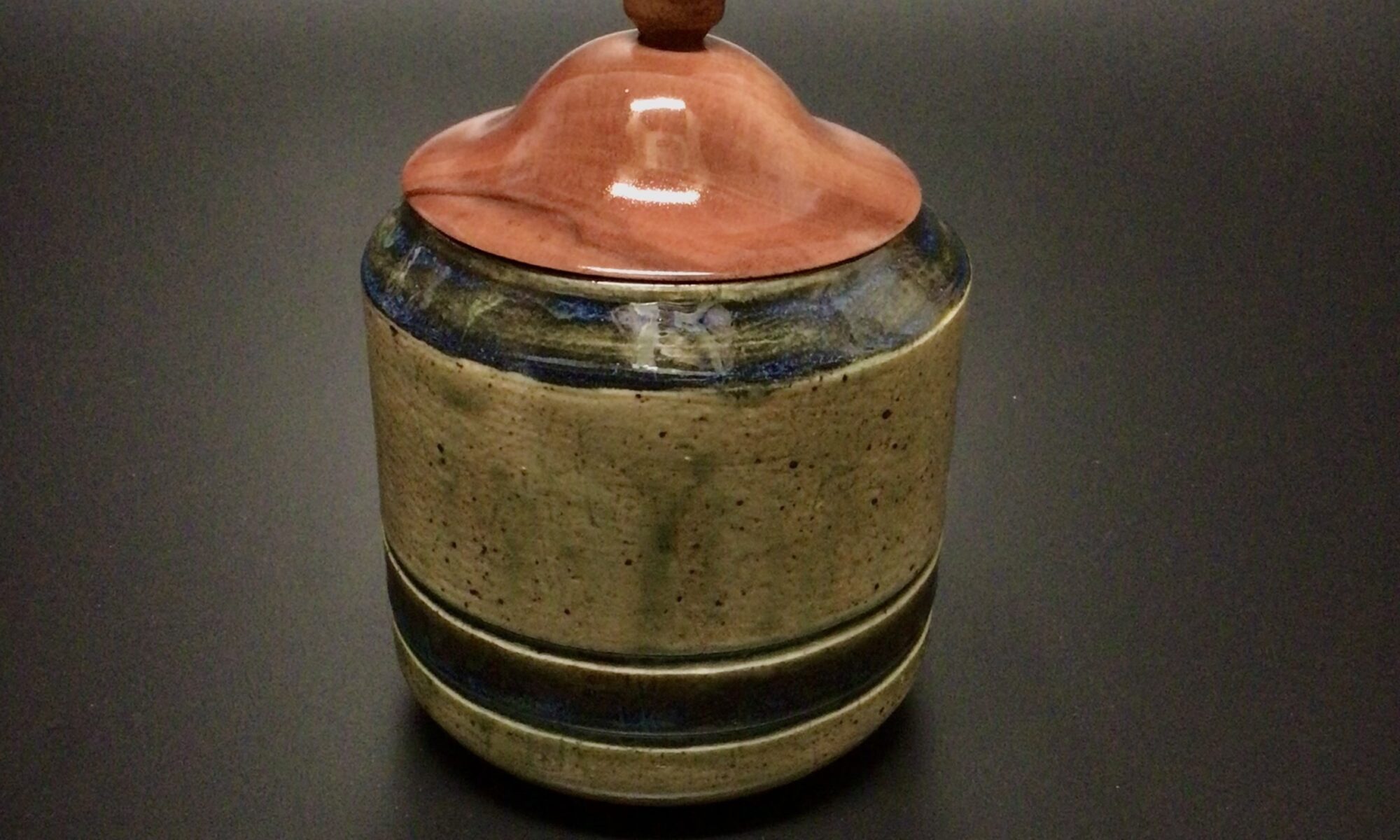 mid fired ceramic jar with a lid turned from salvaged Sea Grape.