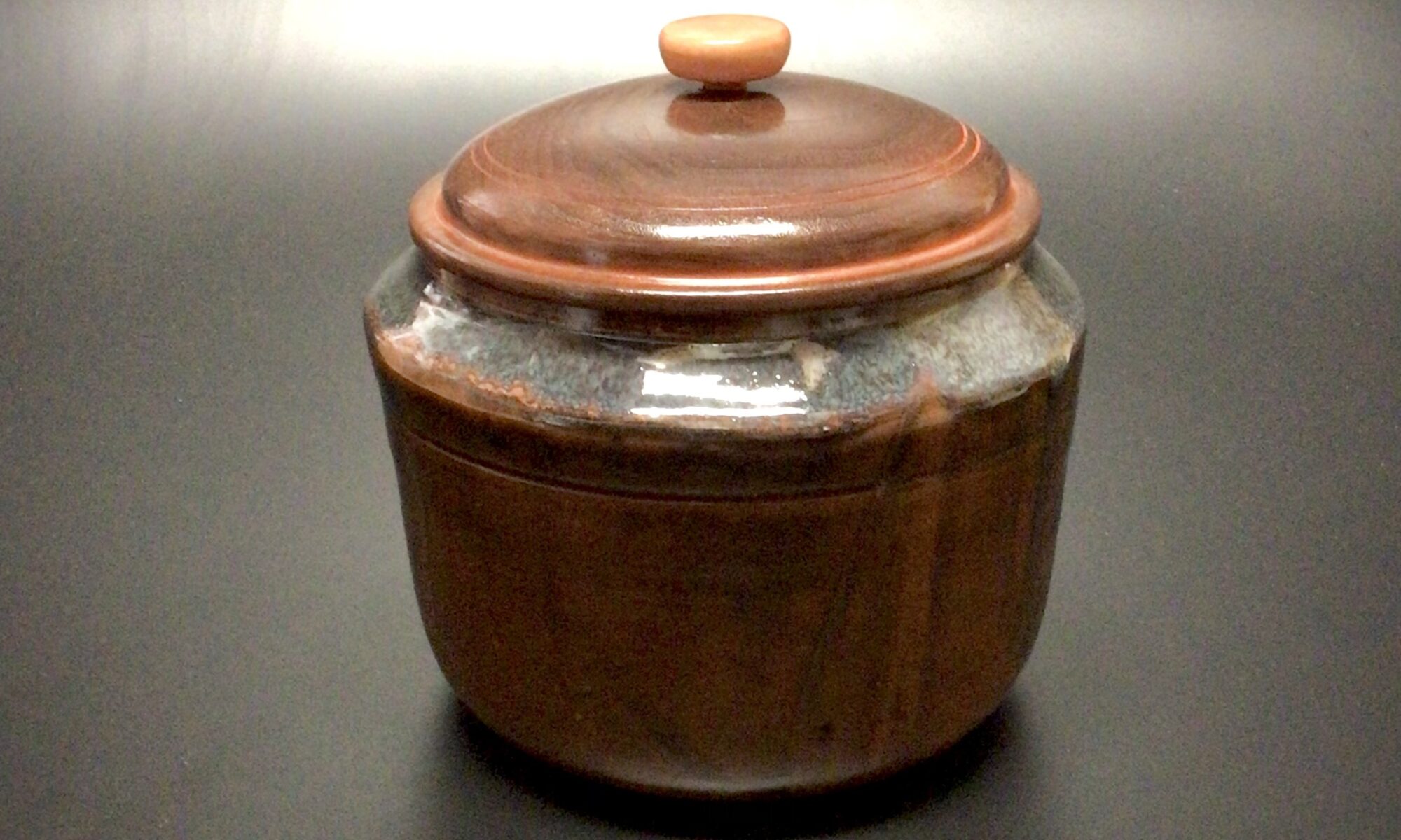 Glazed mid fired ceramic jar with an acrylic latex tinted , turned walnut lid and a turned maple knob